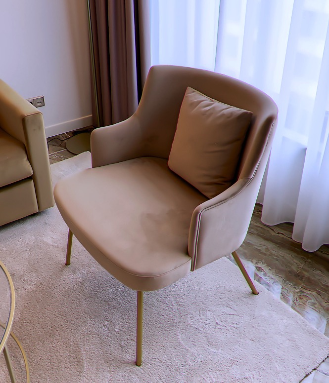 Upholstered armchair in dusty rose by the window